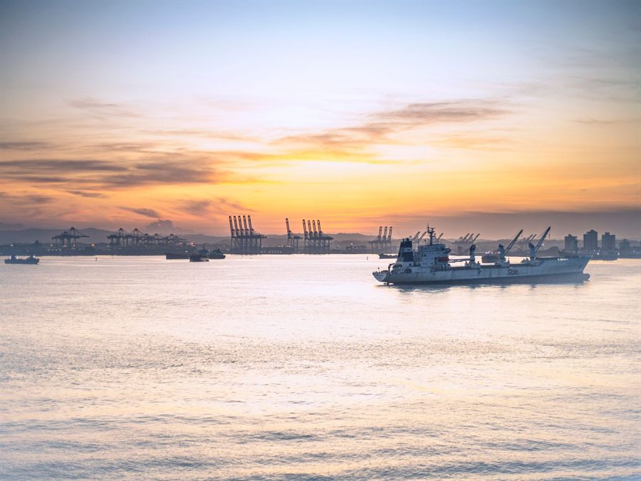 Calm water reflecting a colorful sunset at a Panama Canal port