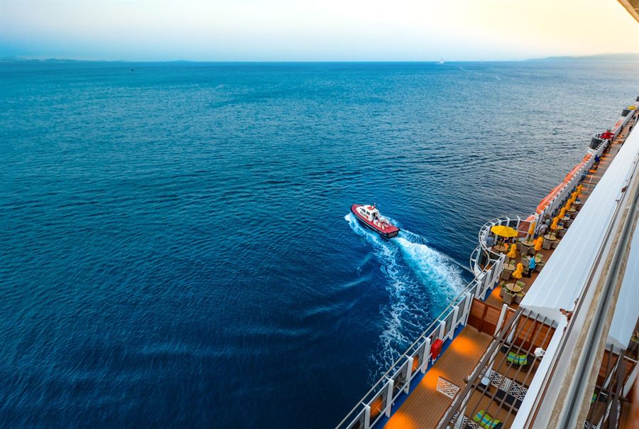 Aerial view of a cruise ship alone on open ocean at sunset