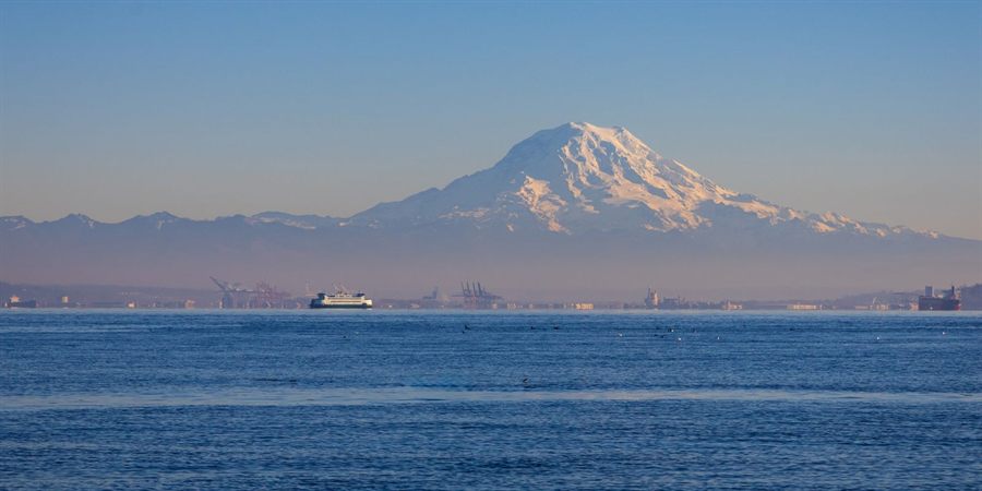 Mount Rainier rising behind the Seattle waterfront and ships on a clear day