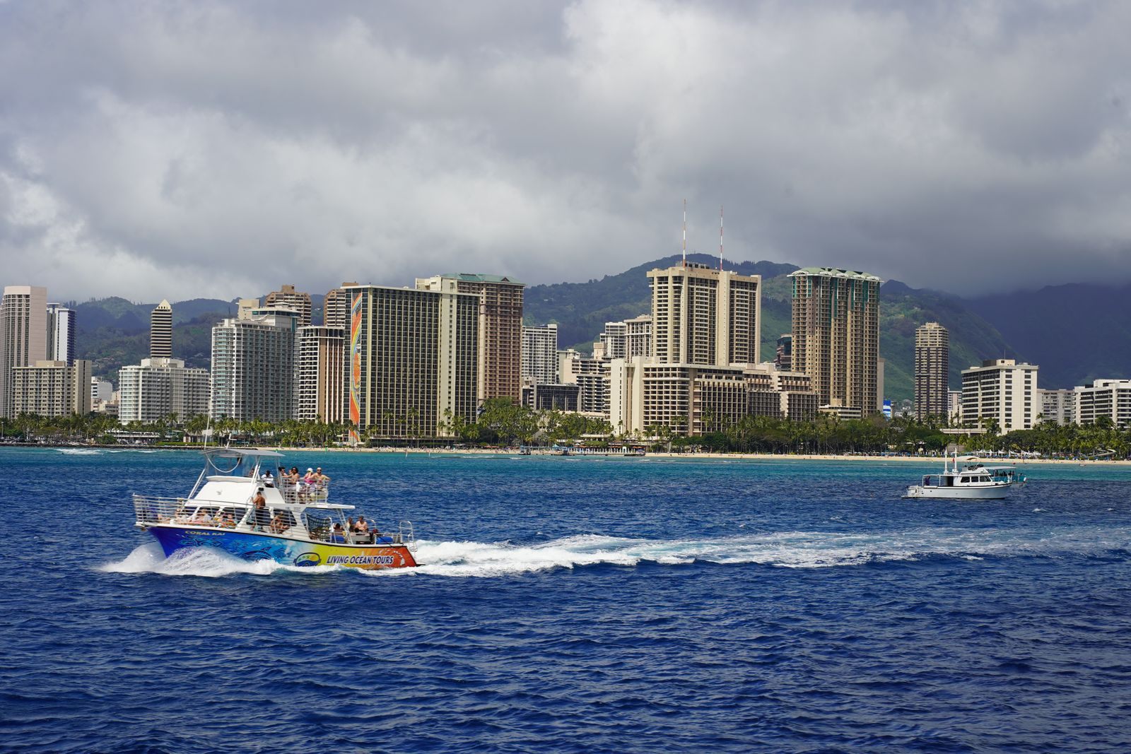 Tour boat speeding past the Waikiki hotel skyline in Honolulu, the island end of Hawaii repositioning cruises